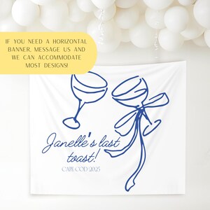 May include: White banner with blue line art of two wine glasses, one with a bow. Text reads "Janelle's last toast! CAPE COD 2025." A yellow banner at the top says "IF YOU NEED A HORIZONTAL BANNER, MESSAGE US AND WE CAN ACCOMMODATE MOST DESIGNS!"