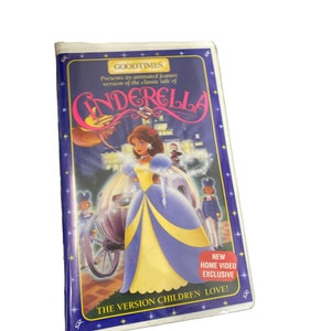May include: A VHS tape featuring an animated version of the classic fairytale Cinderella. The cover features a cartoon image of Cinderella in a blue and yellow ball gown, with a carriage and a prince in the background. The text on the cover reads "Goodtimes Presents its animated feature version of the classic tale of Cinderella. New Home Video Exclusive. The version children love!"