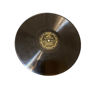May include: A black vinyl record with a gold label. The label has the text "Victor" and "22601-B" and the song title "Out The Bench, Got The Park For The" with the artist "Harry Lauder and the Orchestra".