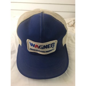 Op de afbeelding: Blauw-witte mesh trucker cap met een witte patch waarop "WAGNER Brake Lighting Products" staat in rood, blauw en wit.
