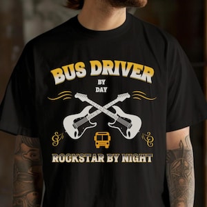 Puede incluir: Camiseta negra con el texto "BUS DRIVER BY DAY ROCKSTAR BY NIGHT" en amarillo y blanco. El diseño incluye guitarras blancas cruzadas y un icono de autobús amarillo, con notas musicales.