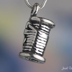 Puede incluir: Encanto de plata en forma de carrete de hilo. El encanto est&aacute; detallado con una superficie texturizada y un bucle para sujetarlo a una pulsera o collar.