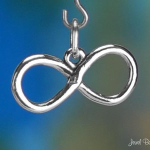 May include: A silver infinity charm with a loop at the top for attaching to a necklace or bracelet.