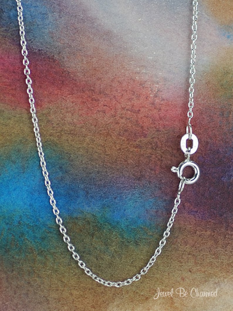 May include: A silver chain necklace with a lobster clasp fastening. The chain is displayed against a colourful background.