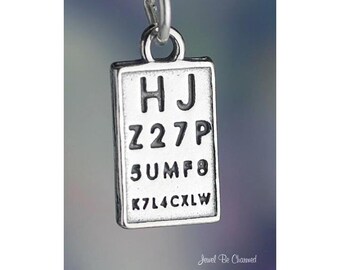 May include: A silver-toned charm in the shape of an eye chart, with the letters and numbers "HJ Z27P 5UMF8 K7L4CXLW" displayed. The charm has a small loop at the top for attachment to a necklace or bracelet.