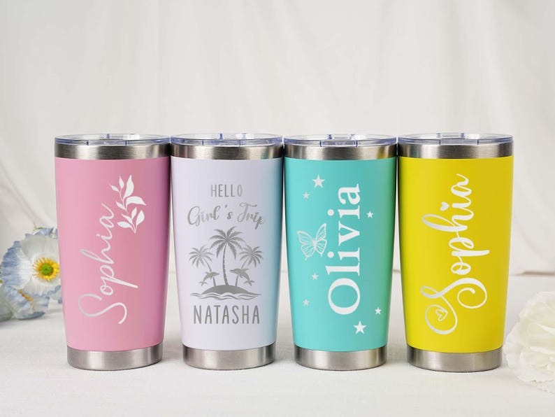 May include: Four stainless steel tumblers in pink, white, teal, and yellow. Each tumbler has a different name in a script font. The pink tumbler has a floral design, the white has a beach scene, the teal has a butterfly, and the yellow has a heart.