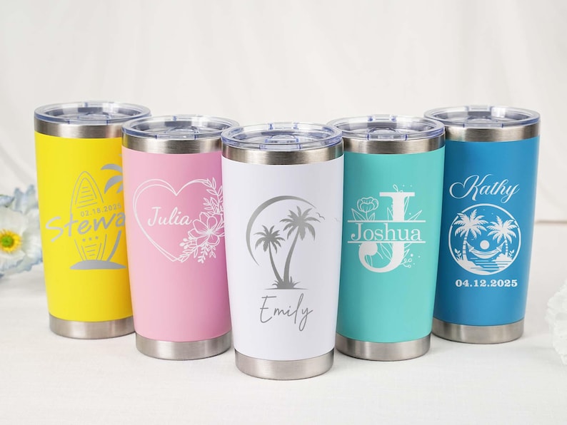 May include: Five stainless steel insulated tumblers in yellow, pink, white, teal, and blue. Each tumbler features a unique design, including names and tropical graphics. The tumblers have silver lids and bases.