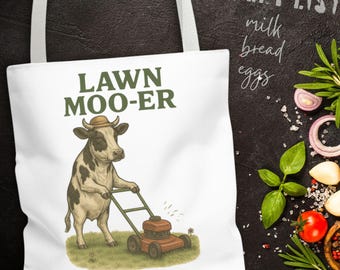 May include: White tote bag with the text "LAWN MOO-ER" and an illustration of a cow mowing the lawn. The cow wears a hat and pushes a red lawnmower. The words "GROCERY LIST" and grocery items are in the background.