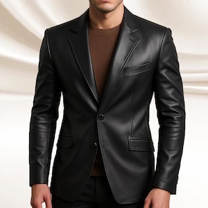 May include: A black leather blazer featuring a notched lapel, single-button fastening, and two front pockets. The tailored blazer is worn over a brown sweater.