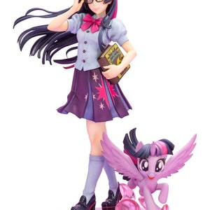 May include: A purple and pink anime figurine of Twilight Sparkle from My Little Pony: Friendship is Magic. She is wearing a blue and white school uniform with a purple skirt and a pink bow. She is holding a book and wearing glasses. A smaller purple and pink pony figurine of Twilight Sparkle is running next to her.