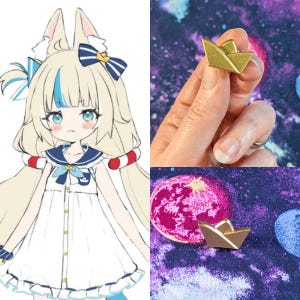 Pode incluir: Um alfinete de barco de papel dourado, exibido em um tecido roxo e azul com tema de galáxia. O alfinete é uma pequena e detalhada réplica de um barco de papel dobrado. Também, uma ilustração de desenho animado de uma menina com uma roupa de marinheiro.