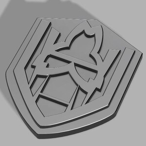 Op de afbeelding: Een grijs, geometrisch, schildvormig ontwerp met een gestileerd, abstract patroon erin.