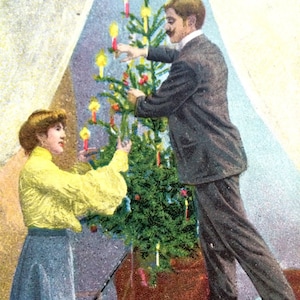 Postal de Navidad victoriana - Hombre y mujer recortando el árbol de Navidad con velas - Postal vintage