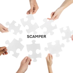 May include: Hands holding white puzzle pieces around the word "SCAMPER" in black text. The puzzle pieces are scattered, with some held close together and others further apart, against a white background.