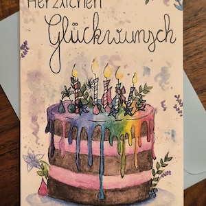 Könnte beinhalten: Eine Grußkarte mit einer Aquarellillustration eines mehrschichtigen Kuchens mit regenbogenfarbenem Glasurguss, gekrönt von fünf brennenden Kerzen und kleinen Blumenakzenten. Der Text "Herzlichen Glückwunsch" steht oben in schwarzer Tinte.