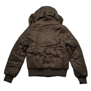 May include: A brown bomber jacket with a hood and faux fur trim. The jacket has a quilted design and ribbed cuffs and hem. The back view shows the hood and the full length of the jacket.