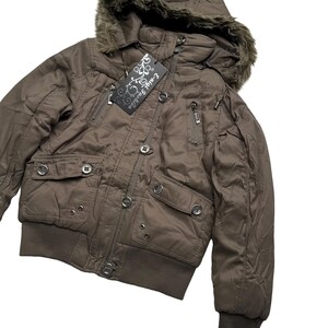 May include: A brown bomber jacket with a fur-lined hood. The jacket features multiple pockets, a zipper closure, and a ribbed hem and cuffs. A tag with the text "E-nigi Fashion" is attached.