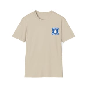 May include: A beige short-sleeved t-shirt with a blue and white Lawson Station logo on the upper left chest. The logo features a stylized milk bottle inside a blue shield with the words "LAWSON STATION" in white.