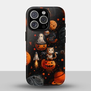 May include: A black phone case featuring a Halloween-themed space design. The case is adorned with orange planets, stars, and illustrations of a ghost, a black cat, a rocket, and a cat sitting on a carved pumpkin.