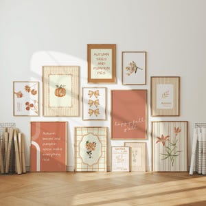 May include: A gallery wall of twelve framed art prints featuring autumn themes, including pumpkins, flowers, bows, and text like Autumn Skies and Pumpkin Pies, Happy Fall Y'all, and Autumn leaves and pumpkin spice make everything nice.