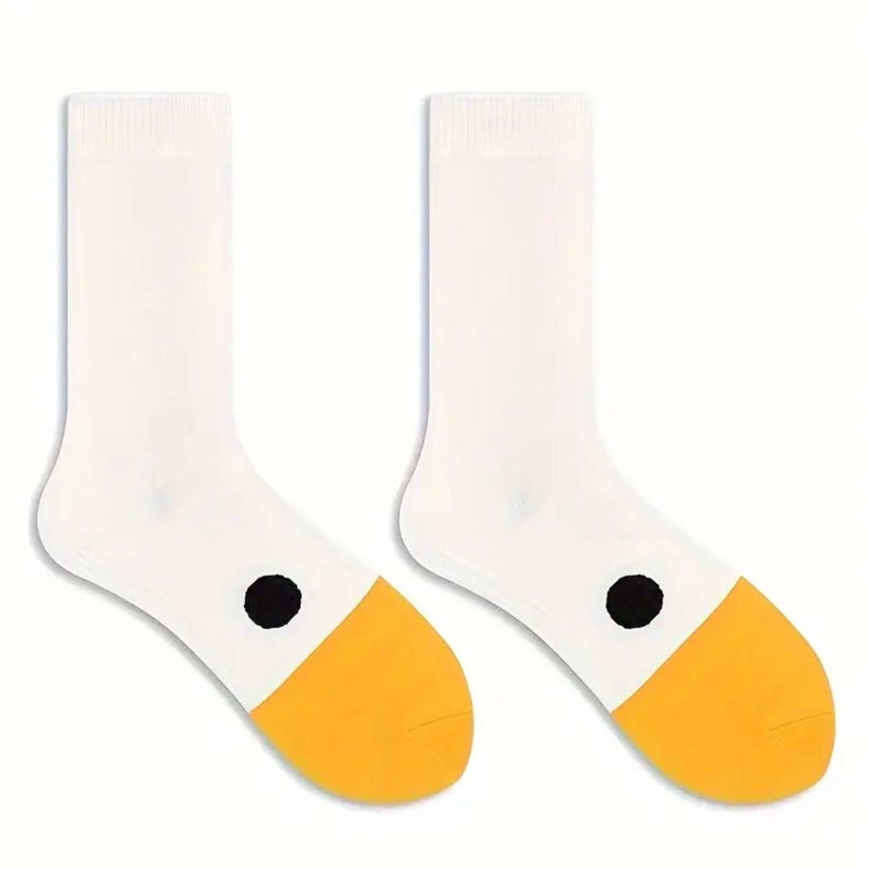 May include: A pair of white socks with yellow toes and a black dot on the side. The socks are made of a soft material and are designed for comfort and style. The socks are a fun and playful accessory.