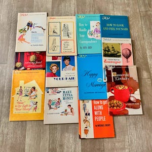 Op de afbeelding: Een verzameling vintage zelfhulpboeken met kleurrijke covers. Titels zijn onder meer "How to Control Your Weight", "Happy Marriage" en "Casserole Cookery". De boeken bevatten illustraties en tekst en bieden advies over diverse onderwerpen.