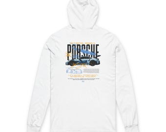 May include: White long-sleeve hoodie featuring a graphic of a blue sports car with the word "PORSCHE" in black and orange. The hoodie also has text that reads "UNLEASH PRECISION, EMBRACE POWER".