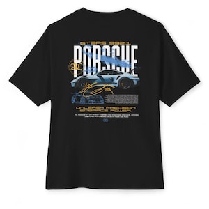 May include: A black short-sleeve t-shirt featuring a graphic on the back with the text PORSCHE, GT3RS 992.1, and UNLEASH PRECISION EMBRACE POWER. The design includes a light blue sports car illustration, a gold signature, and technical text.
