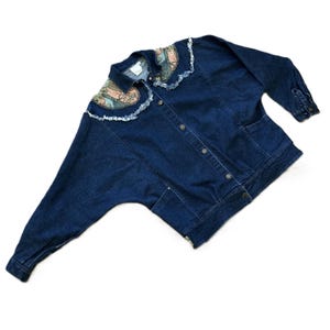 May include: A dark blue denim jacket with a floral print collar and frayed edges. The jacket has a button closure and two pockets.