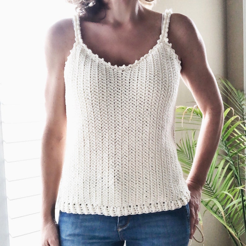 Puede incluir: Un top blanco de crochet con escote festoneado y tirantes. El top est&aacute; hecho con un patr&oacute;n de punto sencillo y tiene un ajuste holgado.
