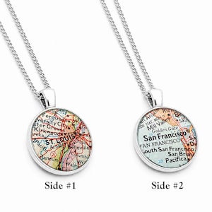 May include: Two silver-toned circular pendants on matching silver chains. The left pendant features a map of St. Louis, Missouri, while the right pendant displays a map of San Francisco, California. Both pendants are labeled Side #1 and Side #2.