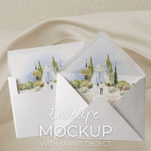 May include: Two white envelopes with a watercolor illustration of a gazebo and trees. The envelopes are open, revealing the artwork inside. Text on the front reads "Envelope MOCKUP WITH SMART OBJECT". The background is a neutral, textured fabric.