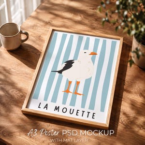 Puede incluir: Una impresión artística enmarcada con una ilustración de gaviota. La obra de arte tiene un fondo blanco con rayas verticales de color azul claro. La gaviota es blanca con acentos de alas negras y patas y pico naranjas. El texto "LA MOUETTE" está en la parte inferior.