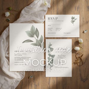 May include: A wedding invitation suite mockup featuring three cards with botanical illustrations and text. The main invitation card is square, with a large leaf design. An RSVP card and a details card are also included, all on a wooden surface.
