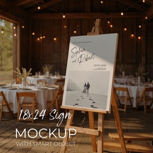 May include: A wooden easel displays a wedding sign with the names "Sophia and Robert" and the date 23.07.2023. The sign is a mockup, measuring 45.7x61 cm, with a black and white photo of a couple on a beach. The scene is set in a rustic venue.