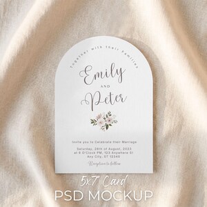 May include: A white, arched wedding invitation card featuring the names "Emily" and "Peter" in cursive. The card includes wedding details for August 28th, 2023, and is a 12.7 x 17.8 cm card mockup.