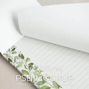 May include: A white notepad with lined pages and a decorative green and white floral border. The notepad is labeled "5x7 Notepad PSD Mockup" with the text "with editable background color".