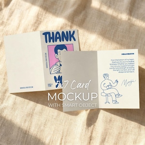 May include: A 5x7 card mockup with a beige background. The card is open, revealing a blue and pink illustration with the word "THANK" in large blue letters. The inside of the card has a handwritten message and a drawing of a person.