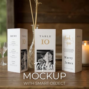May include: A mockup of three white trifold wedding stationery pieces. The centre card reads "Table 10" in gold. The left card is a menu, and the right card says "Thank You". The word "Trifold" and "Mockup" are also visible.