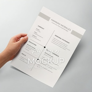 Puede incluir: Una maqueta de papel A4 blanco que presenta un currículum vitae con el nombre "HANNAH MORALES" y el título "Customer Planning Manager". El currículum incluye secciones para información de contacto, educación, habilidades y experiencia laboral. El papel es sostenido por una mano.