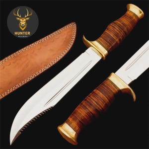 Può includere: Un coltello da caccia con una lama in acciaio lucido e un bordo seghettato. L'impugnatura è in legno scuro con dettagli in ottone. Un fodero in pelle è visibile sullo sfondo. Il logo Hunter Blades è nell'angolo in alto a sinistra.