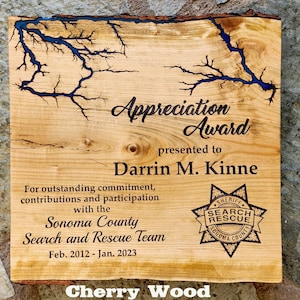 May include: A wooden plaque with a blue epoxy resin design, an appreciation award presented to Darrin M. Kinne for outstanding commitment, contributions and participation with the Sonoma County Search and Rescue Team from February 2012 to January 2023.