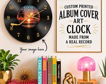 May include: A circular wall clock crafted from a black vinyl record featuring gold numerals and a central image of a sunset with palm trees and the text Good Vibes Deluxe Edition. Beside it, a framed sign reads Custom Printed Album Cover Art Clock.