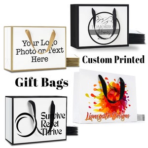 K&ouml;nnte beinhalten: Vier Geschenktaschen mit verschiedenen Designs. Die Taschen sind wei&szlig; mit schwarzem Besatz und schwarzen Griffen. Die Designs beinhalten ein Logo mit dem Text "Tomorrow Homes", ein Design mit bunten abstrakten Formen und dem Text "Lionsgate Designs", ein Design mit einer Welle und dem Text "Survive Reset Thrive" und ein Design mit dem Text "Your Logo Photo or Text Here".