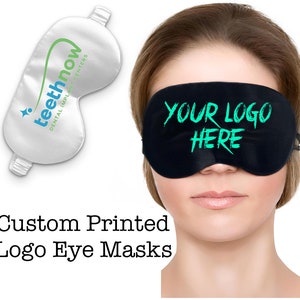 May include: A black sleep mask with the text "YOUR LOGO HERE" in green. The sleep mask is made of soft, comfortable material and is perfect for blocking out light.  Custom printed logo eye masks.