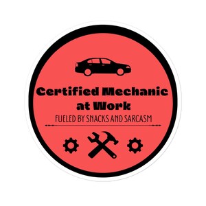 May include: A round sticker with a red background and black border. The sticker features a black car silhouette at the top, with the text "Certified Mechanic at Work" in bold black font. Below the text is "Fueled by Snacks and Sarcasm".