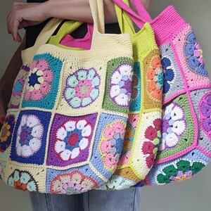 May include: Three colorful, handmade crochet tote bags. Each bag features a patchwork design with floral motifs in various colors, including pink, blue, yellow, and green. The bags have sturdy handles in contrasting colors.