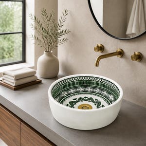 May include: A round white vessel sink featuring an intricate green and white geometric pattern on the interior basin. The sink has a smooth exterior and a central gold-toned drain fixture, designed for placement on a flat countertop surface.