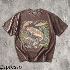 May include: Espresso-colored t-shirt featuring a vibrant graphic of several trout swimming amongst aquatic plants and rocks. The fish display a range of colors, including red, yellow, and green. The shirt has a classic crew neck and short sleeves.