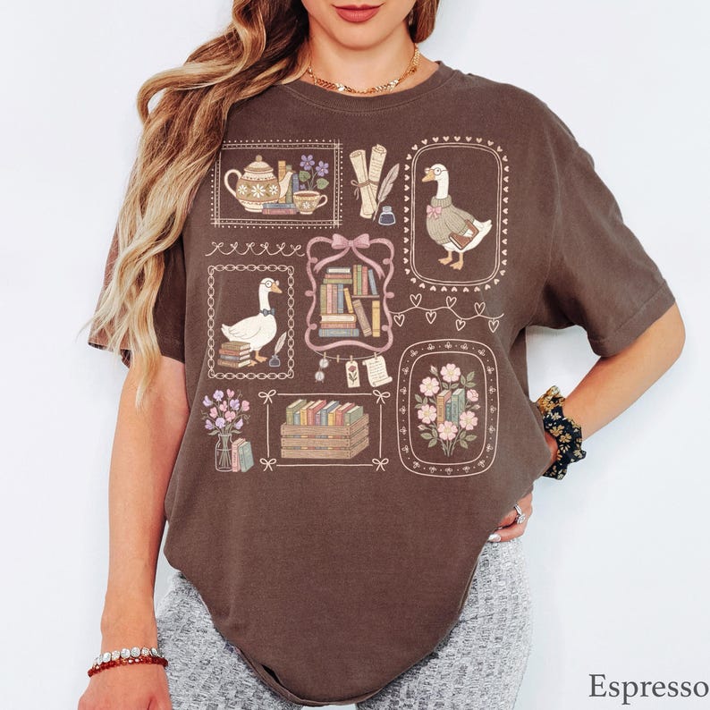 Puede incluir: Una camiseta color espresso con un estampado gr&aacute;fico de varias ilustraciones enmarcadas que incluyen gansos con gafas, pilas de libros, una tetera, pergaminos y arreglos florales, utilizando una paleta de colores apagados en crema, rosa y verde.
